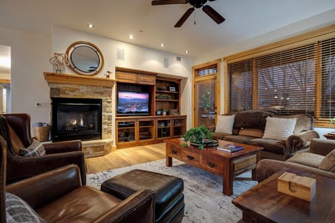 Sink into plush leather seating by your crackling stone fireplace, with entertainment center and warm wood accents creating the perfect retreat.