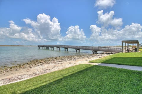 Scenic waterfront location featuring a wooden pier extending over calm waters with maintained green spaces nearby.