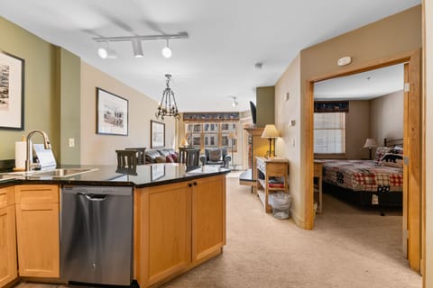 Relax in your open-concept space where modern kitchen flows into cozy living area, perfect for unwinding after mountain adventures.