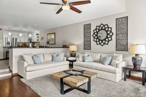 Sink into plush white sofas surrounded by elegant decor and cooling ceiling fans in your spacious retreat.