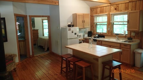 Great room w/ kitchen/bar counter and view into bedroom and bathroom with shower