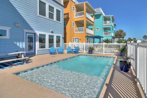 Your private pool paradise awaits with crystal-clear waters and bright blue poolside chairs for perfect relaxation.