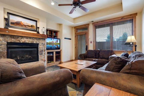 Unwind in your cozy living room with plush leather seating, crackling fireplace, and entertainment center for perfect mountain getaway evenings.