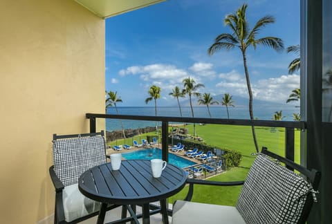 Sip your morning coffee from your private balcony, where swaying palms frame the sparkling pool, manicured lawn, and endless ocean stretching toward the horizon.
