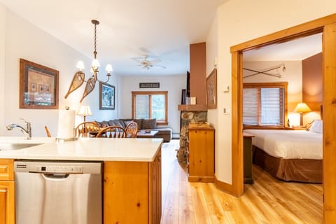 Relax in your cozy mountain retreat with warm wood accents, full kitchen, and comfortable living space flowing seamlessly into the bedroom.