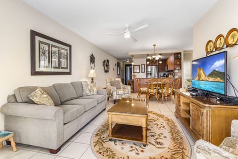 Unwind in your tropical-inspired living space featuring plush seating, coastal décor, and tropical artwork that evokes island charm. Your open-concept layout seamlessly connects to a fully equipped kitchen and dining area.