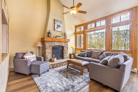 Unwind in your cozy living room where mountain views frame plush seating and a crackling fireplace awaits your return from adventure.