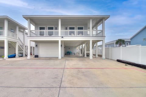 This elevated beach house features covered parking, outdoor living spaces, and balcony access in a coastal neighborhood setting.
