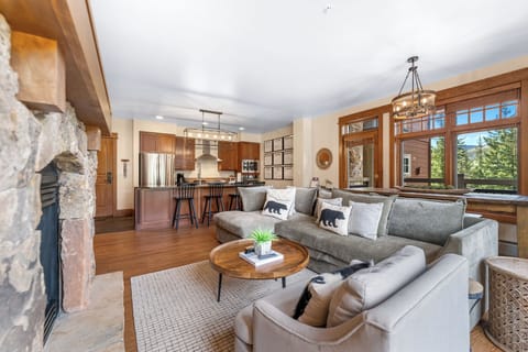 Sink into the plush sectional by your crackling fireplace, where warm wood beams frame mountain views through expansive windows.
