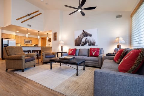 Relax in your spacious living room with cozy seating and rustic touches, connected to a fully equipped kitchen for memorable evenings together.