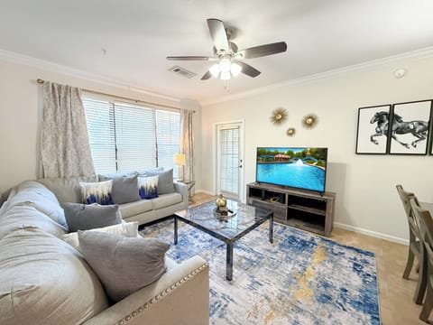 Bright Orlando vacation rental living room with sectional sofa, flat-screen tv, and modern décor.