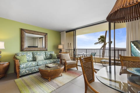 Relax in your inviting island-inspired living room with tropical décor and an open balcony offering ocean breezes and panoramic sea views.
