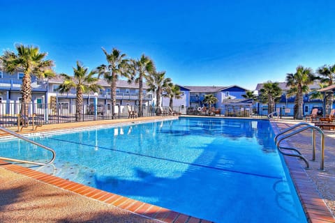 Sparkling resort-style pool surrounded by swaying palms creates your perfect tropical escape under brilliant blue skies.