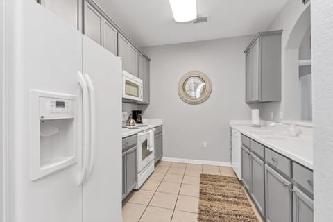 Gourmet kitchen of the condo in Orlando Florida - Contemporary design with clean lines and minimalist aesthetics - Smart use of space with versatile storage solutions - Fully equipped with all kitchen accessories and stainless steel appliances