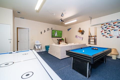 Sports themed games room showing TV pool table, and air hockey table