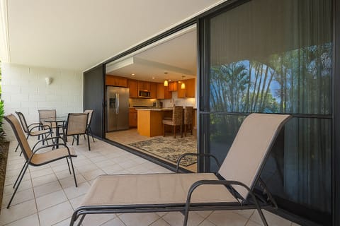 Unwind on your private balcony with tropical garden views, seamlessly connected to a bright, modern kitchen perfect for easy meal prep and dining.