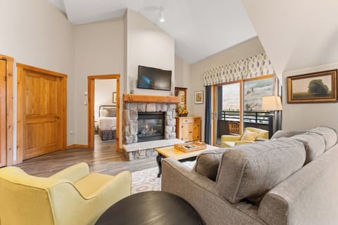 Sink into plush sofas by your stone fireplace while mountain views fill the windows of this elegant living space.