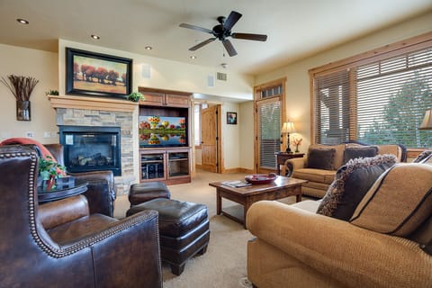 Unwind in your spacious living room featuring plush leather seating, a cozy stone fireplace, and entertainment center for perfect evenings together.