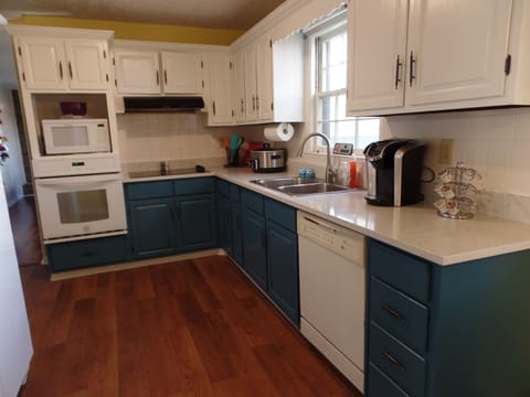 Quartz Countertops, stylish kitchen, Keurig, Microwave, Oven, and tools to cook.