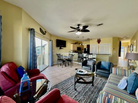 Unwind in your spacious open-concept living area where colorful coastal furniture and plenty of seating create the perfect gathering spot for family memories.