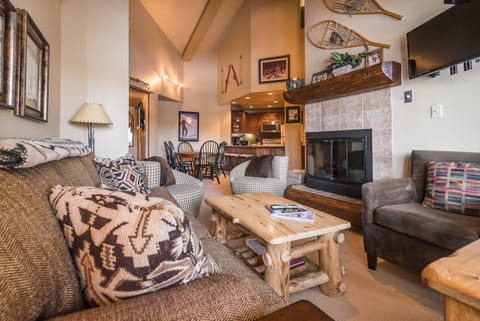 Cozy up in this rustic living space with comfy seating, warm fireplace, and authentic mountain lodge charm perfect for relaxing evenings.