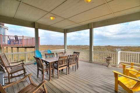 Relax on your expansive covered deck with panoramic views, perfect for memorable meals and peaceful moments with colorful coastal scenery stretching endlessly.