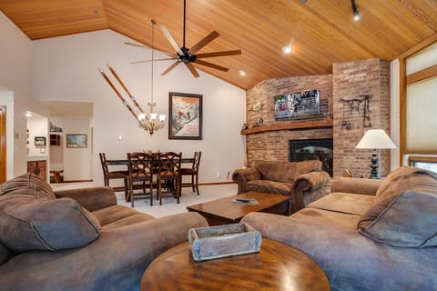 Sink into plush sofas by the crackling fireplace, where vaulted ceilings and rustic charm create your perfect mountain retreat.