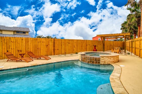 Dive into your private oasis with a sparkling pool and relaxing hot tub, surrounded by tropical palms under endless blue skies.