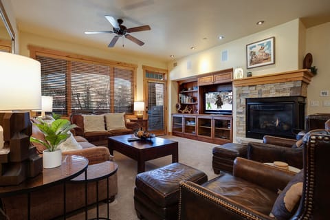 Relax in this inviting living room with leather seating, entertainment center, and cozy fireplace for your mountain evenings.