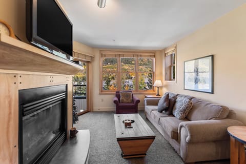 Curl up by your cozy fireplace while enjoying stunning mountain views from your comfortable sofa in this warm, inviting living space.