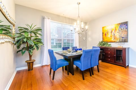 The  elegant six-seater dining table, complemented by comfortable chairs and a captivating chandelier casting vibrant lighting. Every meal is a celebration of comfort, elegance, and cherished moments shared together.