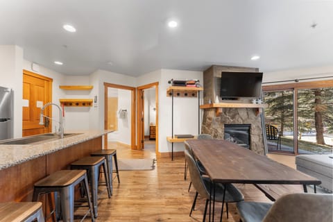 Gather around your spacious dining table while warmth from the stone fireplace fills this open-concept retreat, perfectly designed for memorable mountain getaways.