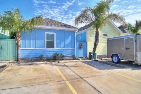 Charming blue cottage with palm trees and dedicated parking awaits your arrival in this sunny coastal setting.