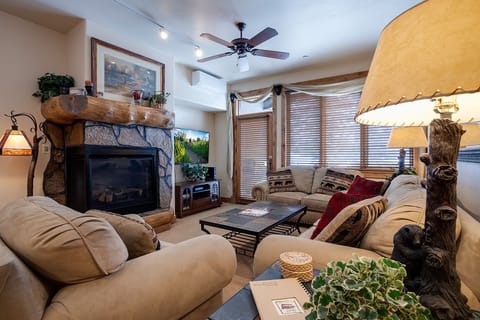 Sink into plush sofas by your stone fireplace, where warm lighting and mountain charm create the perfect spot for evening relaxation.