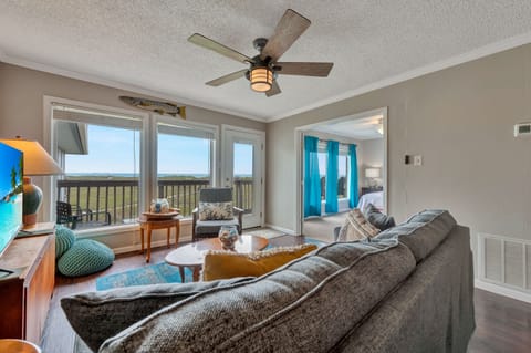 Unwind in your bright living space with plush seating, scenic views, and a gentle ceiling fan creating perfect comfort for relaxation.