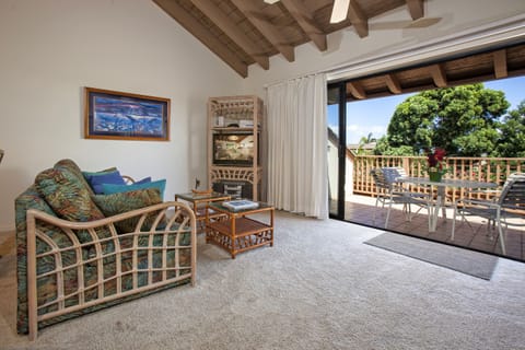 Relax in your coastal-inspired living room with exposed beam ceilings, opening directly to your private terrace where tropical breezes and island views await your arrival.