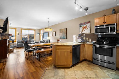 Enjoy your open-concept space with gleaming hardwood floors, stainless steel appliances, and cozy living area perfect for mountain getaways.