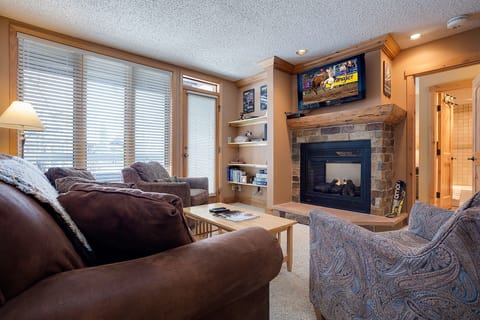 Cozy up in your spacious living room with plush seating, a crackling stone fireplace, and entertainment center for perfect mountain evenings.