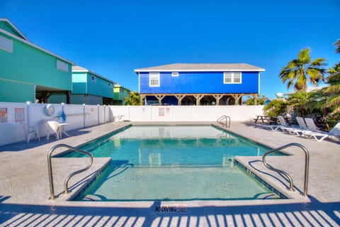 Dive into crystal-clear waters surrounded by colorful beach houses and swaying palms under endless blue skies.