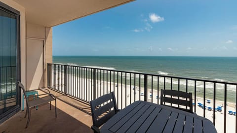 Savor the fresh air on the balcony with seating, overlooking the beach and gentle waves for a relaxing escape