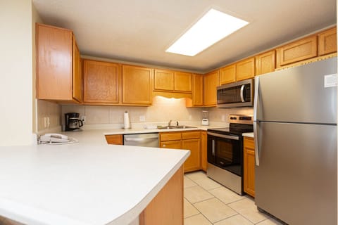 Prepare meals in the spacious kitchen featuring ample cabinetry, stainless appliances, and a convenient breakfast bar