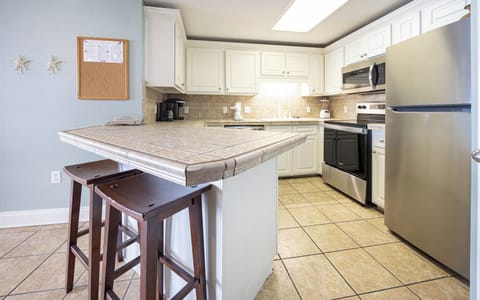 Prepare meals in the functional kitchen featuring stainless steel appliances and a convenient coffee corner with a Keurig