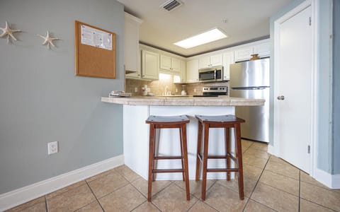 Enjoy casual meals at the breakfast bar with wooden stools, surrounded by a bright and inviting kitchen space