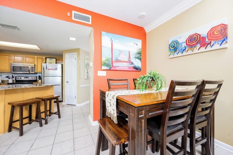 Gather around the wooden dining table, surrounded by vibrant decor and a view that invites relaxation and connection