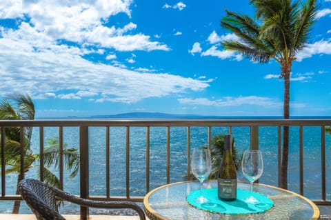 Panoramic oceanfront balcony with island views and swaying palm trees, offering an ideal spot for relaxing with tropical breezes and blue horizons.