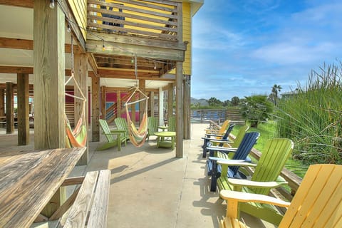 Swing gently in your hammock while colorful Adirondack chairs invite afternoon lounging on this breezy covered deck.