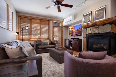 Unwind in your cozy living room with stone fireplace, plush seating, and entertainment center.