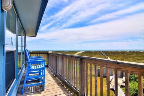 Elevated deck overlooking coastal landscape with wooden boardwalk and natural vegetation stretching toward the horizon.