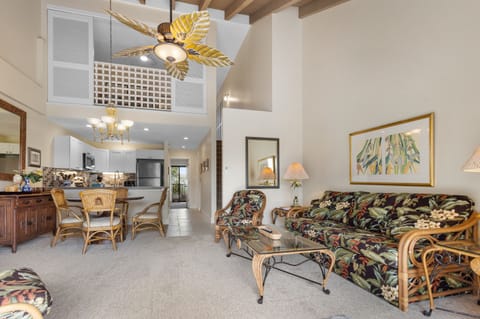 Step into your bright, open retreat with soaring ceilings and tropical charm. Sink into the floral-print seating, cook in your full kitchen, and dine under the palm-leaf fan as natural light fills every corner.