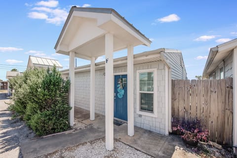 Charming beachside cottage with welcoming covered entry and coastal charm in a peaceful residential setting.